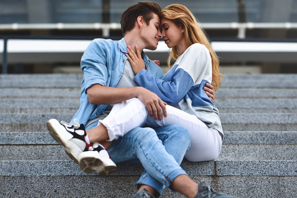 Happy to spending time together. Young beautiful couple outdoor fashion portrait. Attractive boy and girl hugging and kissing. - Fotografie, Obrázek