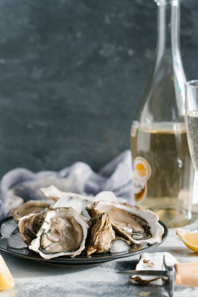 新鮮な牡蠣、レモン部分とシャンパンの織り目加工の卓上にビューをクローズ アップ - 写真・画像