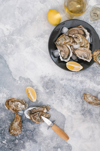 vista superior de ostras frescas, cubitos de hielo, champagne y trozos de limón en la mesa texturizada
 - Foto, imagen