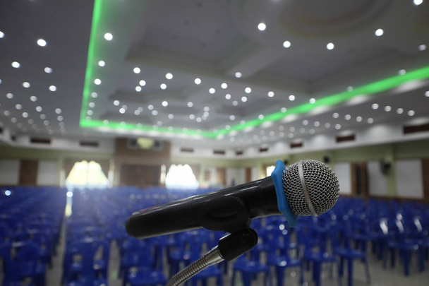 Mikrofon znajduje się na podium stoisko na środku sali pokryta jest czerwony dywan szmatką biały stoły i krzesła i przygotować przed rozpoczęciem seminarium spotkanie. - Zdjęcie, obraz