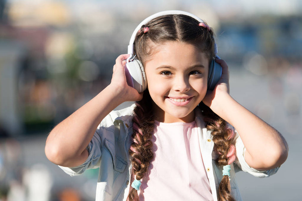 Enjoy life being happy. Music makes me happy. Happy little child. Little child listen to music outdoor. girl wear headphones. Little music fan. I am very happy - Foto, Imagem