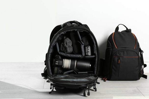 Backpacks with professional photographer's equipment on floor indoors - Foto, Imagem