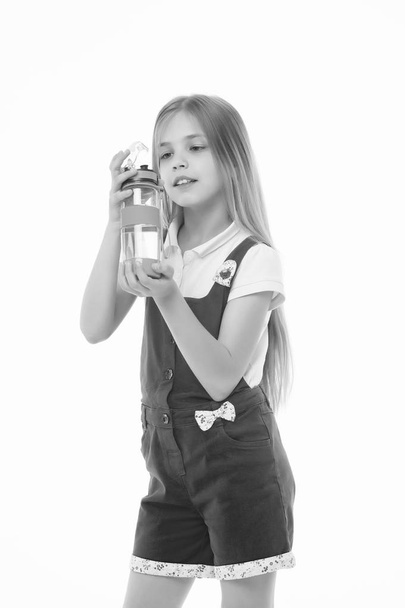 Girl hold water bottle isolated on white. Little child with plastic bottle. Only clean and fresh water. Thirst and health. Childhood. Stay hydrated and healthy. Drinking water for health - Foto, imagen