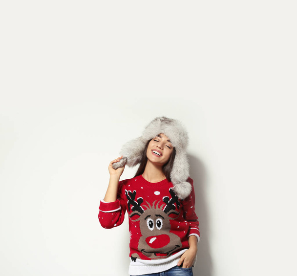 Young woman in Christmas sweater and hat on white background - Photo, image