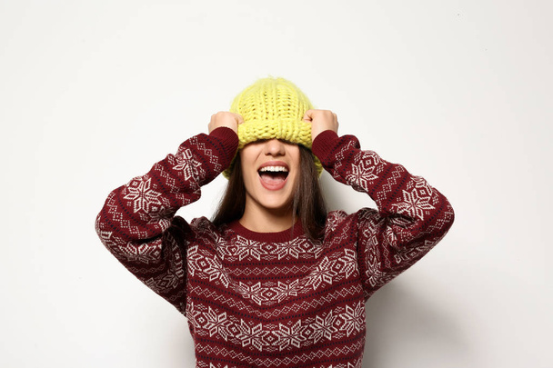 Young woman in warm sweater and knitted hat on white background. Celebrating Christmas - Φωτογραφία, εικόνα