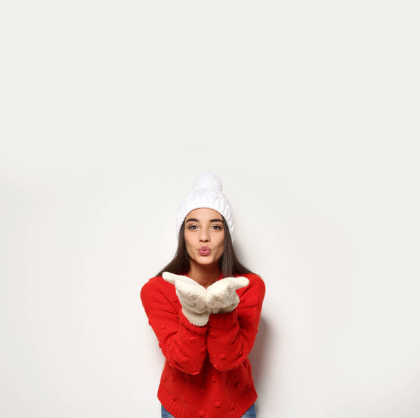 Young woman in warm sweater and hat on white background. Celebrating Christmas - Fotoğraf, Görsel
