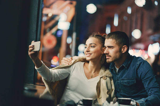 couple using phone in a cafe - Φωτογραφία, εικόνα