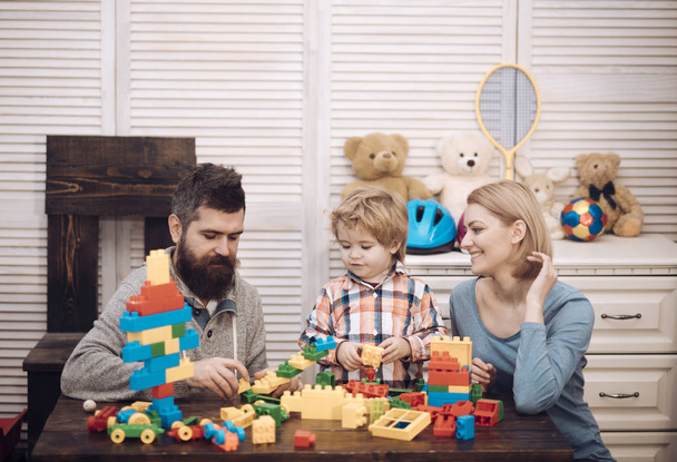 Little boy with dad and mom. happy childhood. Care and development. father and mother with child play constructor. happy family and childrens day. little boy play with parents at home. Family day - Фото, изображение