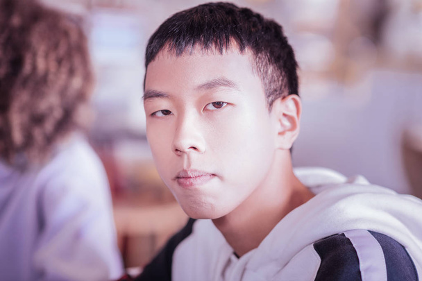 Портрет серьезного азиатского подростка, позирующего на камеру
 - Фото, изображение
