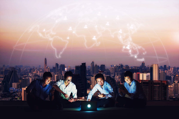 Asian business group in casual suits using smartphone, tablet and laptop for working or social networks. Business and technology concept - Photo, Image