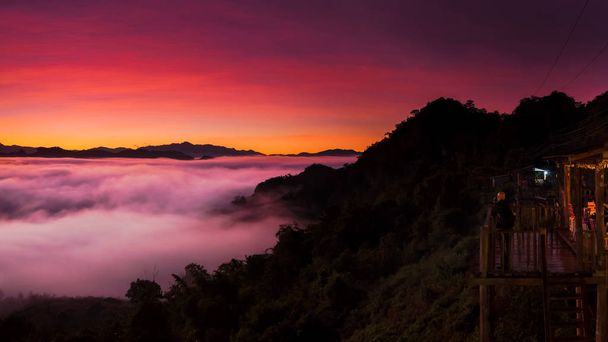 Πανόραμα βουνό τοπίο και το πρωί ομίχλη με σουτ του φωτογράφου σε καμπίνες, καταφύγια με ομίχλη στη το πρωί, το Baan Jabo άποψη. Μάε Χονγκ Σον, το Baan Jabo ένα από τα πιο καταπληκτικά ομίχλη στην Ταϊλάνδη. - Φωτογραφία, εικόνα