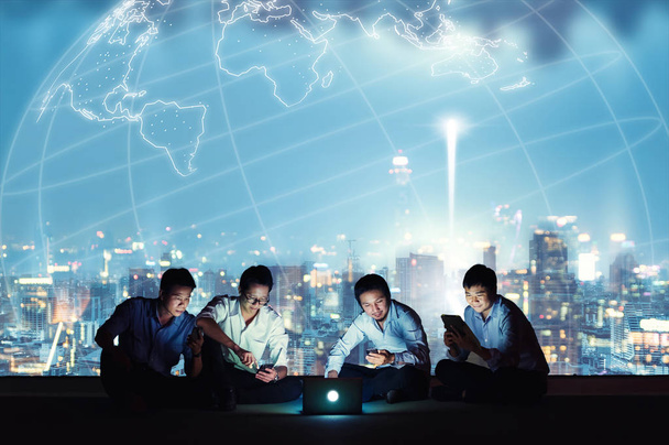 Azjatycki biznes grupy w garniturach dorywczo za pomocą smartfona, tabletu i laptopa do pracy i społeczne sieci. Koncepcja biznesu i technologii - Zdjęcie, obraz