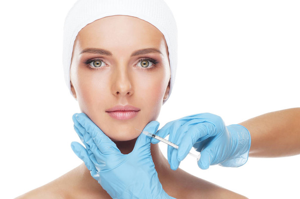 Arzt spritzt einer jungen Frau eine Spritze ins schöne Gesicht. Plastische Chirurgie, Hautstraffung und ästhetisches Medizinkonzept. - Foto, Bild