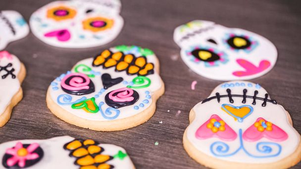 flat lay of sugar skulls decorated with different color royal icing. - Photo, Image