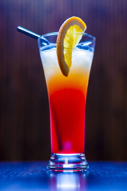 This long cocktail called Tequila Sunrise and the ingredients are Tequila Silver, Orange Juice, Grenadine syrup and Ice. - Фото, изображение