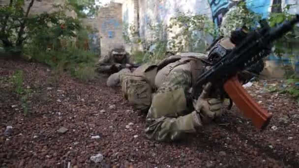 Marineinfanteristen der Spezialeinheiten mit Waffen und taktischen Geräten kriechen während der militärischen Ausbildung auf eine feindliche Position zu. Soldaten schleichen sich bei Anti-Terror-Training in Feindesland ein. - Filmmaterial, Video