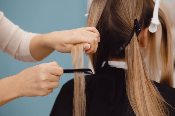 Master combs hair to client for restoration procedure in salon - Fotografie, Obrázek