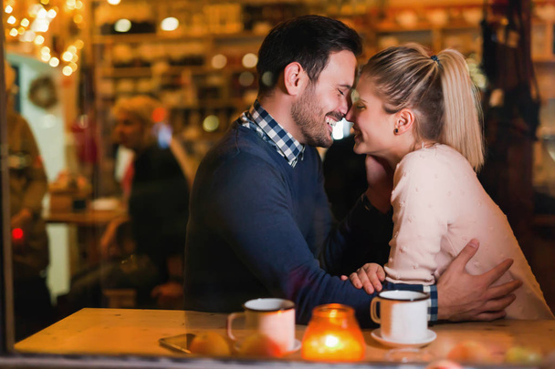 Young attractive and happy couple on date in bar - Foto, Imagen