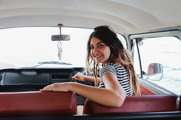 young woman driver smiling and look back on road trip - Fotografie, Obrázek