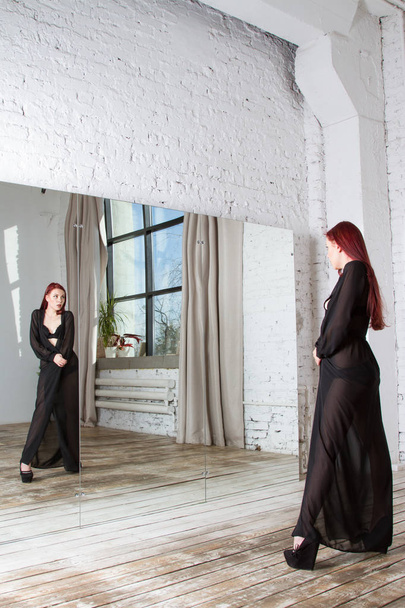 Fille en lingerie noire et peignoir transparent est debout près du miroir
 - Photo, image