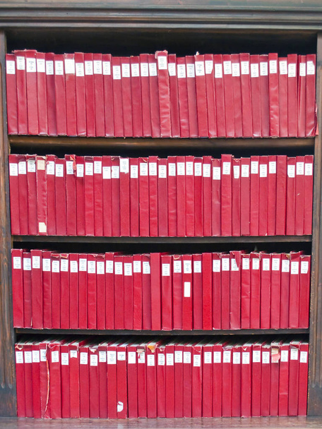 Estantes de libros rojos situados uno al lado del otro
  - Foto, Imagen