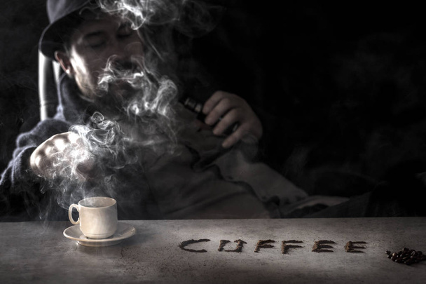 the inscription coffee on the table, a man in blur smokes an electronic cigarette on the background - Фото, изображение
