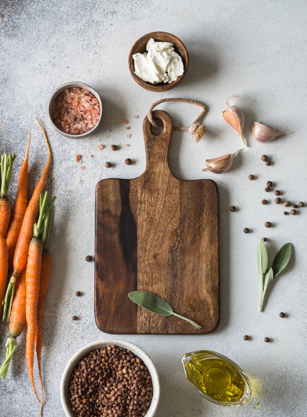 Ingredienti per la cottura delle carote al forno. Lenticchie, formaggio, spezie, erbe e aglio. Lavagna al centro per la registrazione delle ricette
 - Foto, immagini