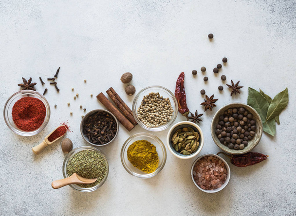 Various spices in bowls on the table. dry herbs, salt spices on a gray background. Top view. Copy space - Foto, imagen