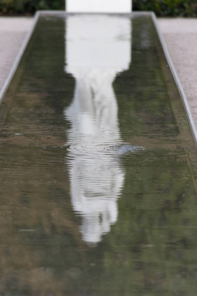 en un parque al aire libre en el sur de Alemania figurita barroca se muestra reflejado en la cuenca del agua
 - Foto, Imagen