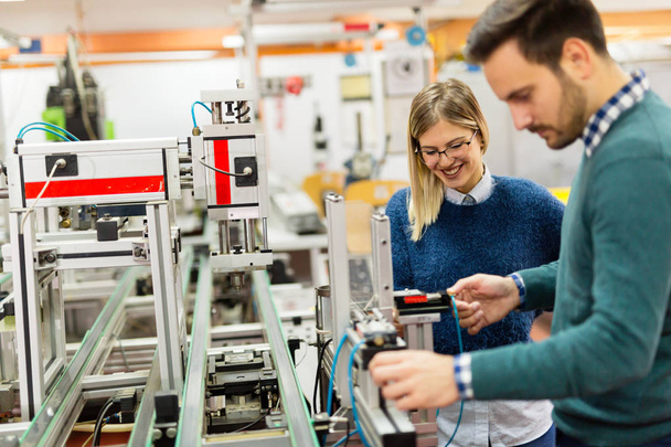 Young attractive students of mechatronics working on project together - Fotoğraf, Görsel