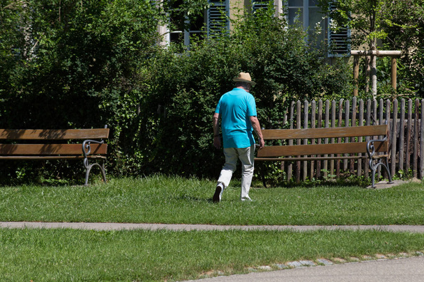 On hyvin aurinkoinen päivä kesäkuun Etelä-Saksassa näet seniority hyvät ja herrat luostari puistossa istuu penkillä tai kävely pohjoismainen kävelykepit
 - Valokuva, kuva