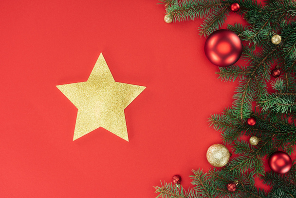 couché plat avec branches de pin avec boules de Noël rouges et dorées et étoile dorée isolée sur rouge
 - Photo, image