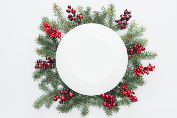 Верхний вид на сосновый венок с рождественскими украшениями и круглое пустое пространство в середине изолированы на белом
 - Фото, изображение