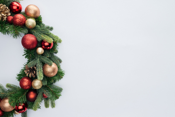 白で隔離赤と金色のクリスマスおもちゃで装飾的なお祝い花輪の上から見る - 写真・画像