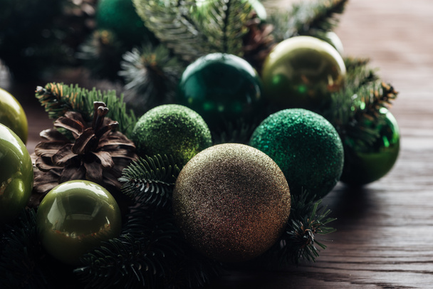 close up view of pine tree wreath with green christmas balls on wooden background - Φωτογραφία, εικόνα