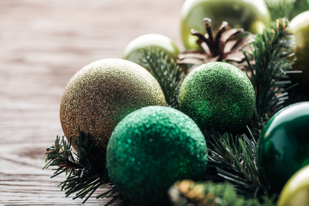 close up view of pine tree wreath with green christmas balls on wooden background - 写真・画像