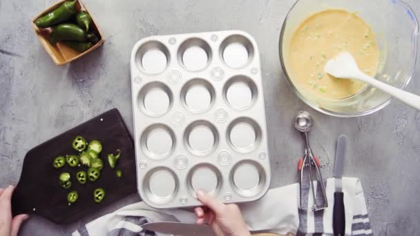 Naispuolinen kokki laittaa muffinssi pannulla maissileipää pöydälle
 - Materiaali, video