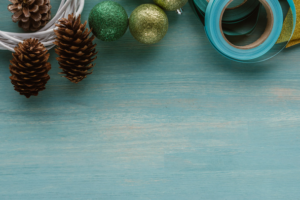 青い木製表面上の松ぼっくりと手作りクリスマス リース飾りトップ表示 - 写真・画像