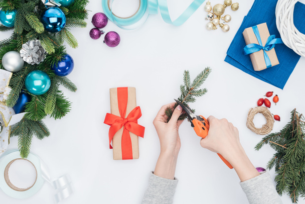 vue partielle de la femme décorant Noël présent avec branche de pin isolé sur blanc
 - Photo, image