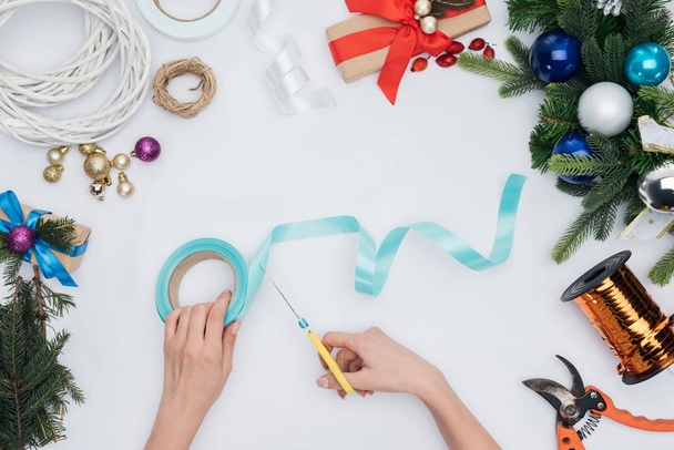 osittainen näkymä nainen leikkaamalla sininen nauha sakset eristetty valkoinen, joulu koristelu käsite
 - Valokuva, kuva