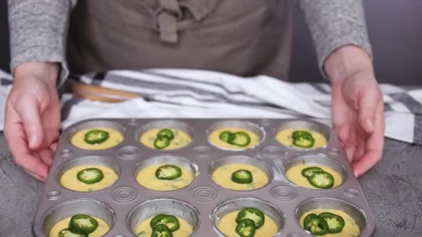 Oříznutý pohled na ženské šéfkuchař připravuje cupcakes kukuřičný chléb s jalapeňo papričkou v muffin pánev - Záběry, video