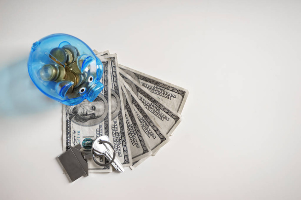 Piggy bank, money and keys on white background. Concept of saving money for buying new house - Foto, Imagen