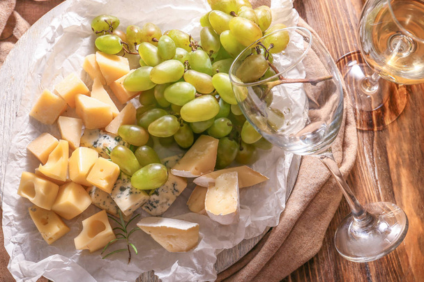 Ώριμα σταφύλια με τυρί και κρασί στο ξύλινο τραπέζι - Φωτογραφία, εικόνα