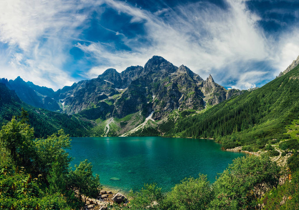 Вид на озеро бірюзового кольору між високими і скелястими горами. Красивий альпійський пейзаж
.  - Фото, зображення