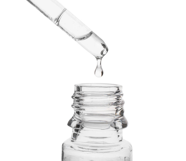 Liquide coulant de la pipette dans une bouteille en verre sur fond blanc
 - Photo, image