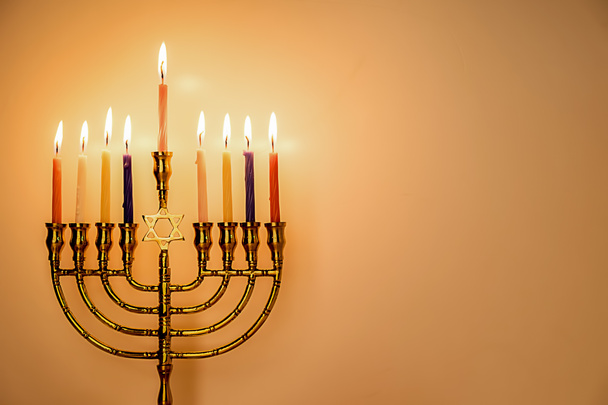 木製の背景を持つユダヤ人の休日のための色のキャンドルを燃焼とハヌカ本枝の燭台. - 写真・画像