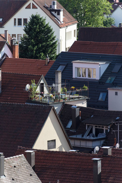 patio van de daken en terrassen met chemin oven en tuinmeubilair op een zeer zonnige dag in juni in Zuid-Duitsland in het midden van een historische stad - Foto, afbeelding