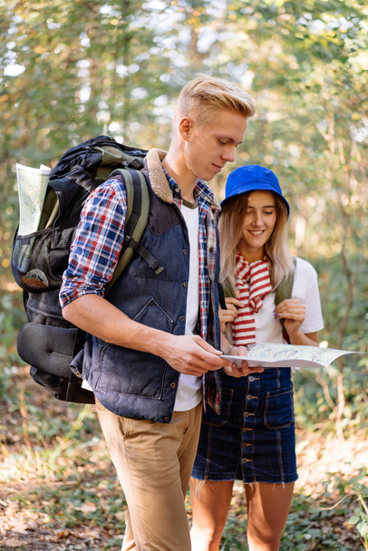 Young couple learning the route in the traveler map on hiking - Fotoğraf, Görsel