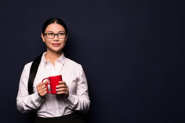 Businesswoman enjoying coffee break holding red cup - Fotoğraf, Görsel