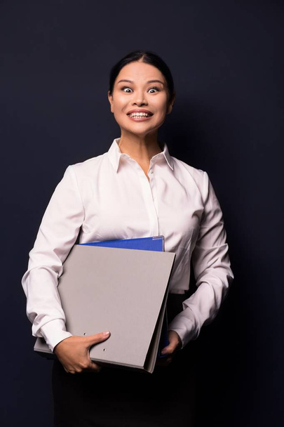 Porträt einer jungen glücklich lächelnden Geschäftsfrau mit Mappe - Foto, Bild